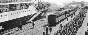 Banner-Victorian-infantry-embarking-on-HMAT-Hororata-A20-at-the-Port-Melbourne-pier.-At-left-is-HMAT-Orvieto