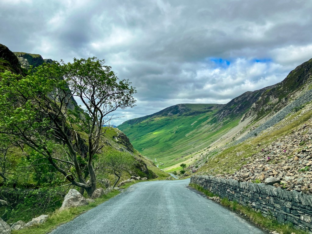 A road winding down into a valley from a high mountain pass