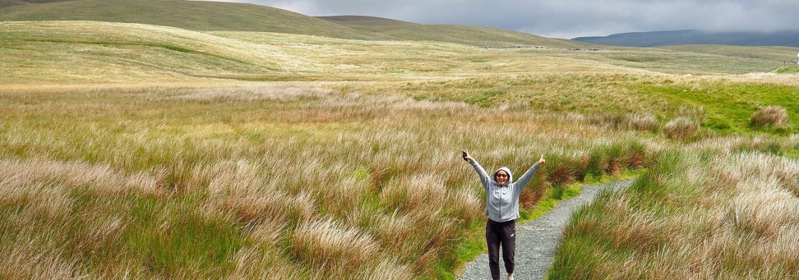 A person with arms raised in the middle of nowhere