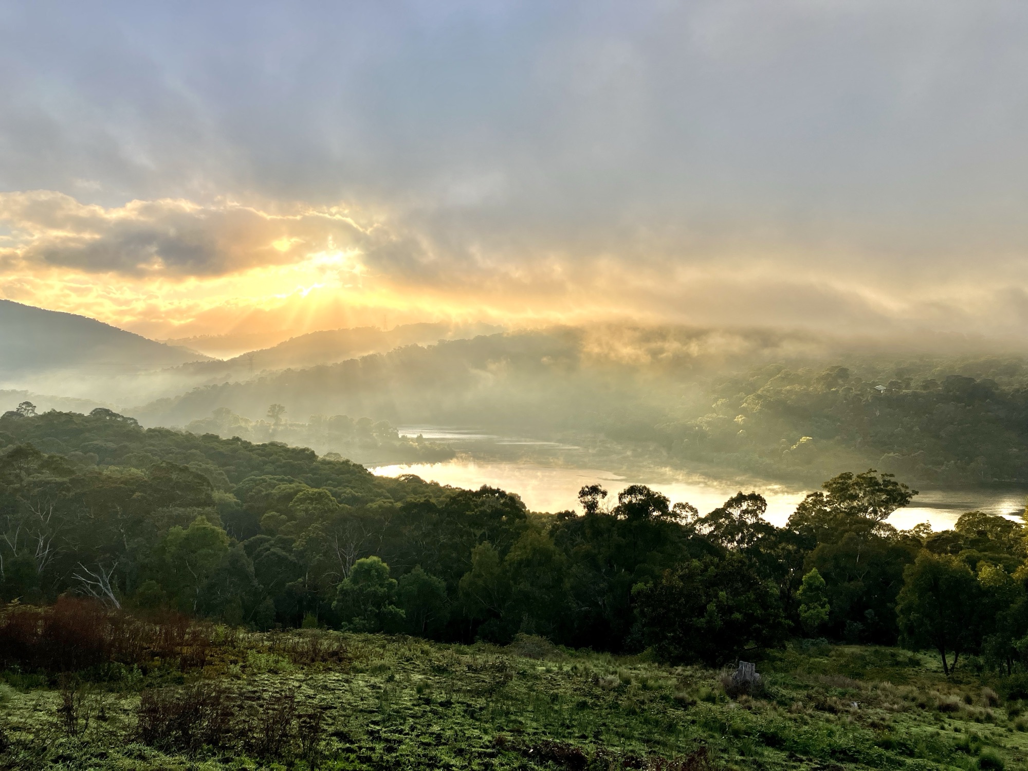 Sunlight and morning mist rising from a lake
